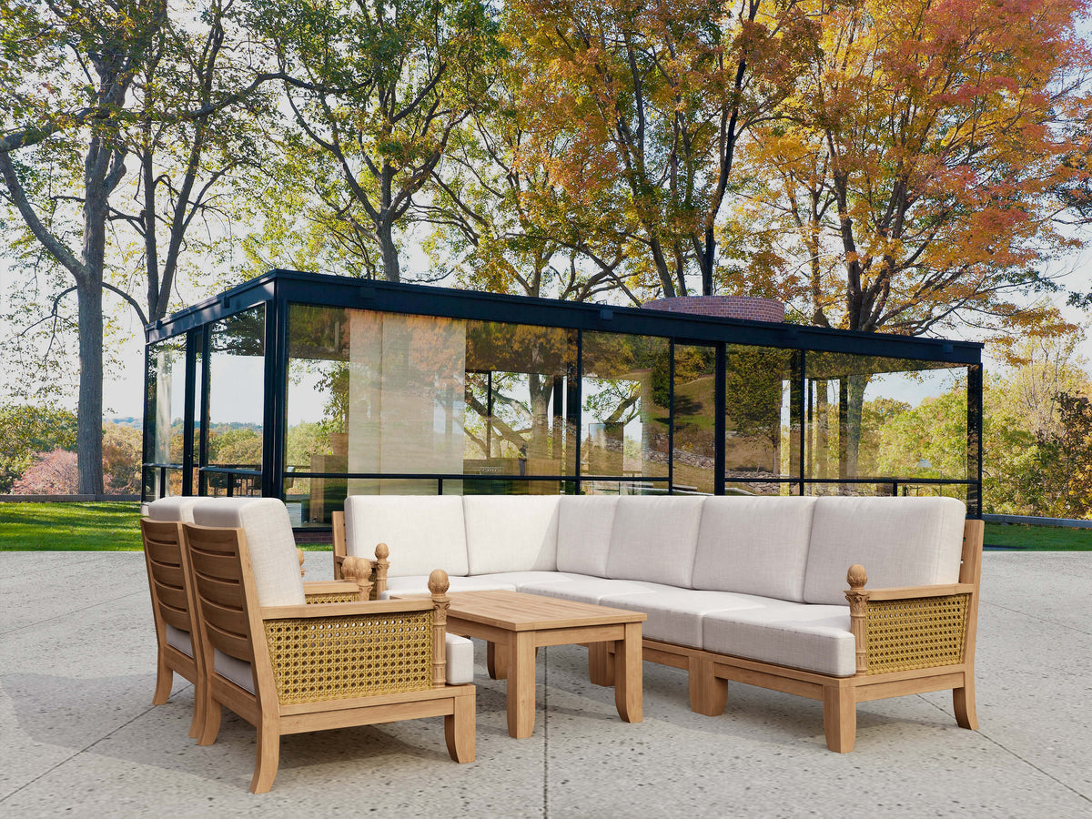 Outdoor patio set with wooden furniture and beige cushions in a park setting.