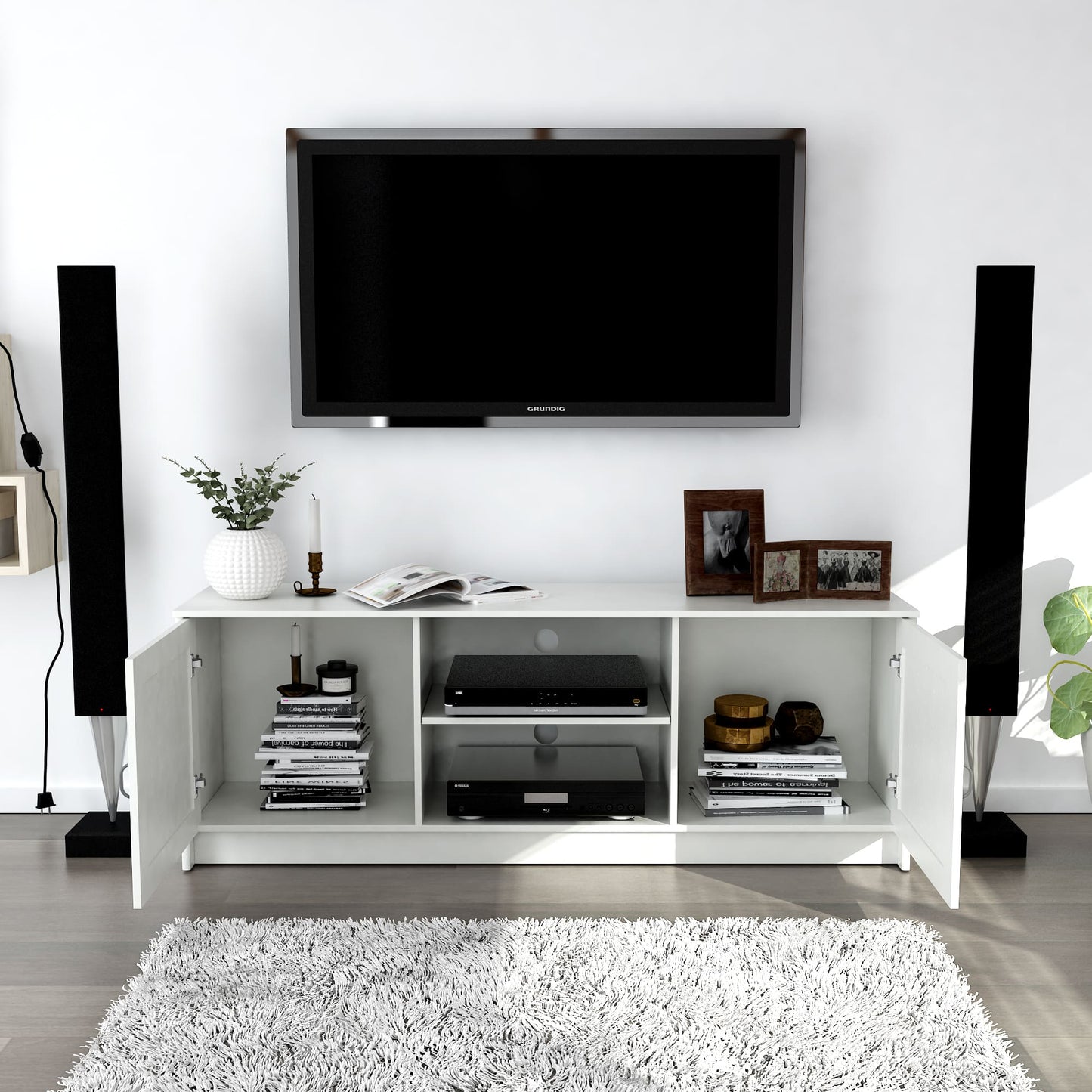 Modern living room with a white entertainment console, TV, and decorative items.