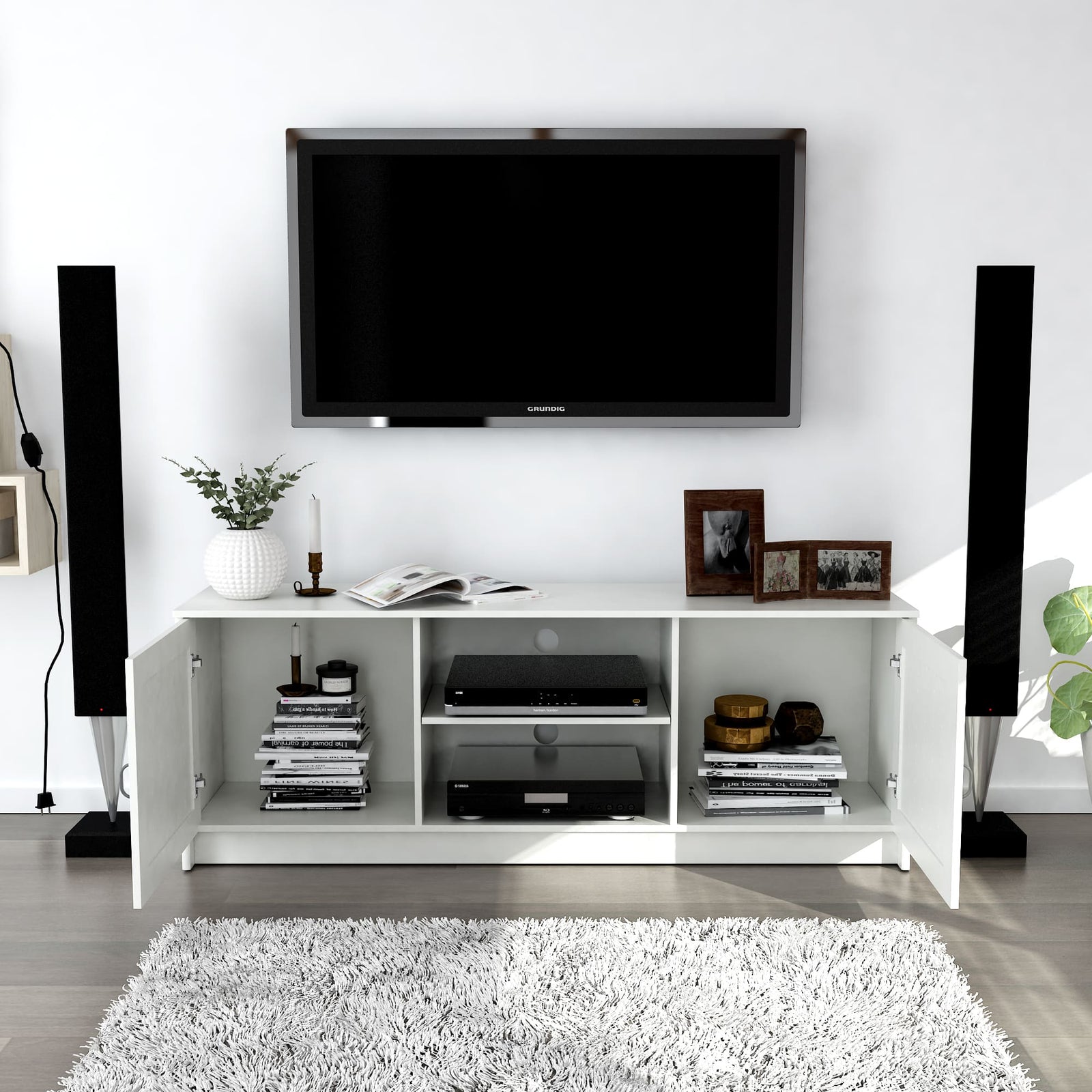 Modern living room with a white entertainment console, TV, and decorative items.