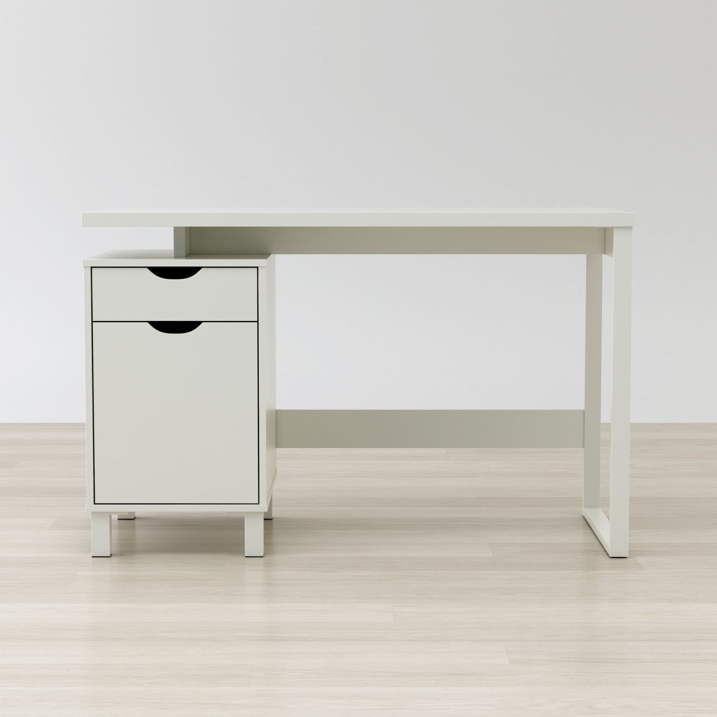 White desk with a small cabinet on a light wooden floor against a white wall