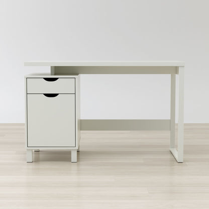 White desk with a small cabinet on a light wooden floor against a white wall