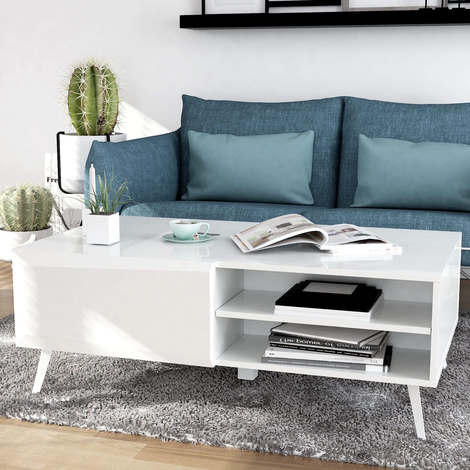Modern living room with a blue sofa, white coffee table, and decorative items.