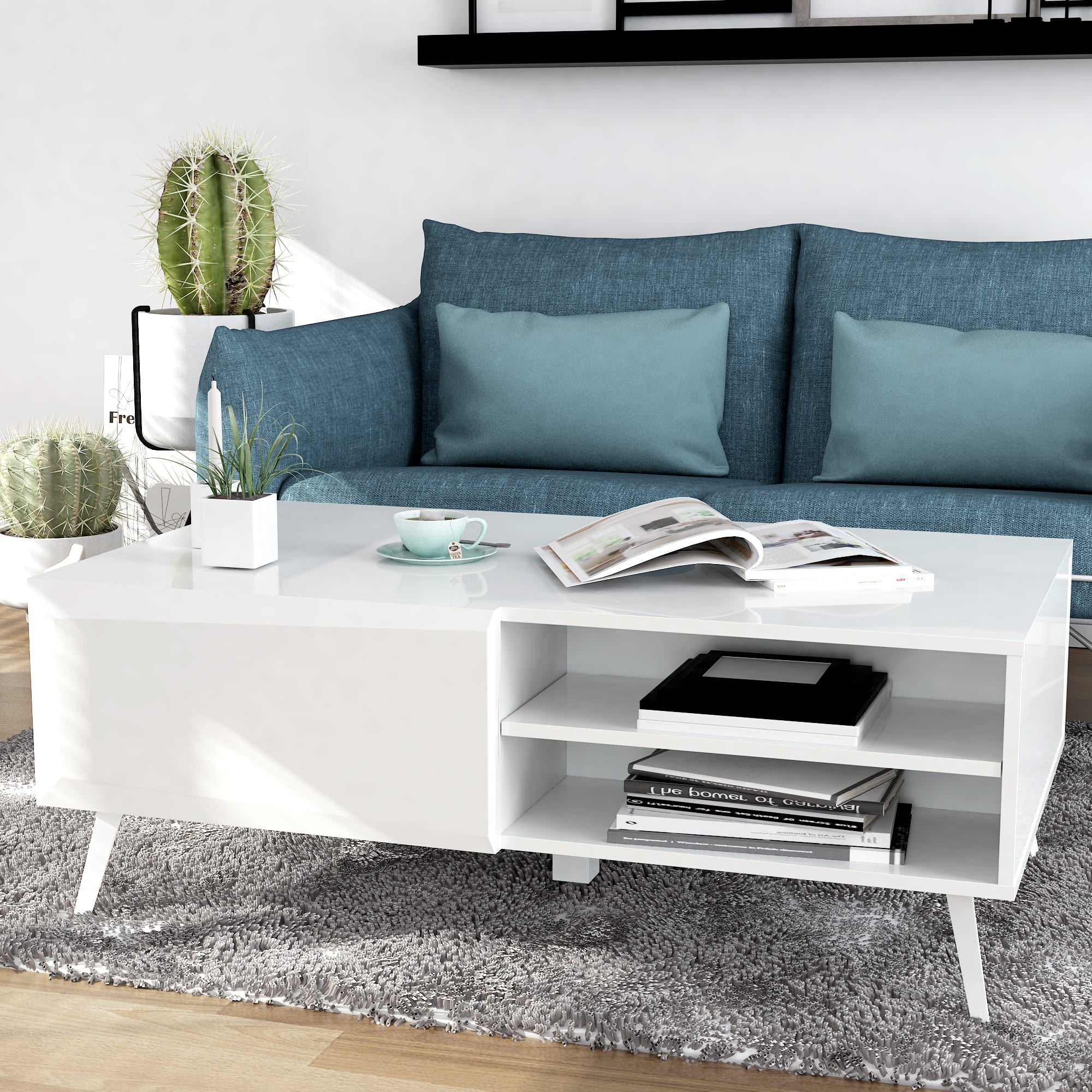 Modern living room with a blue sofa, white coffee table, and decorative items.