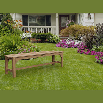 Wooden bench on a well-maintained lawn with flowers and a house in the background