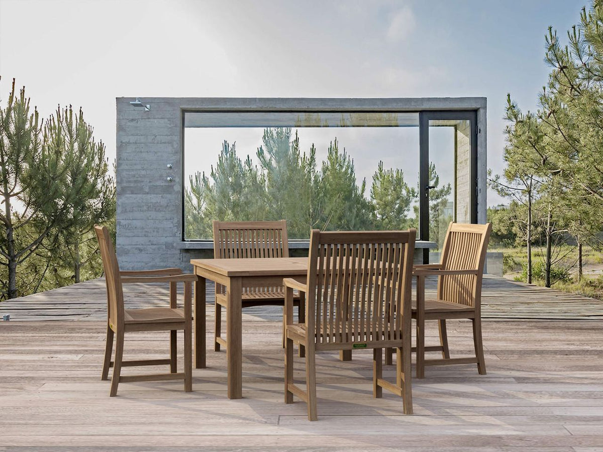 Outdoor dining set on a wooden deck with a modern building and trees in the background