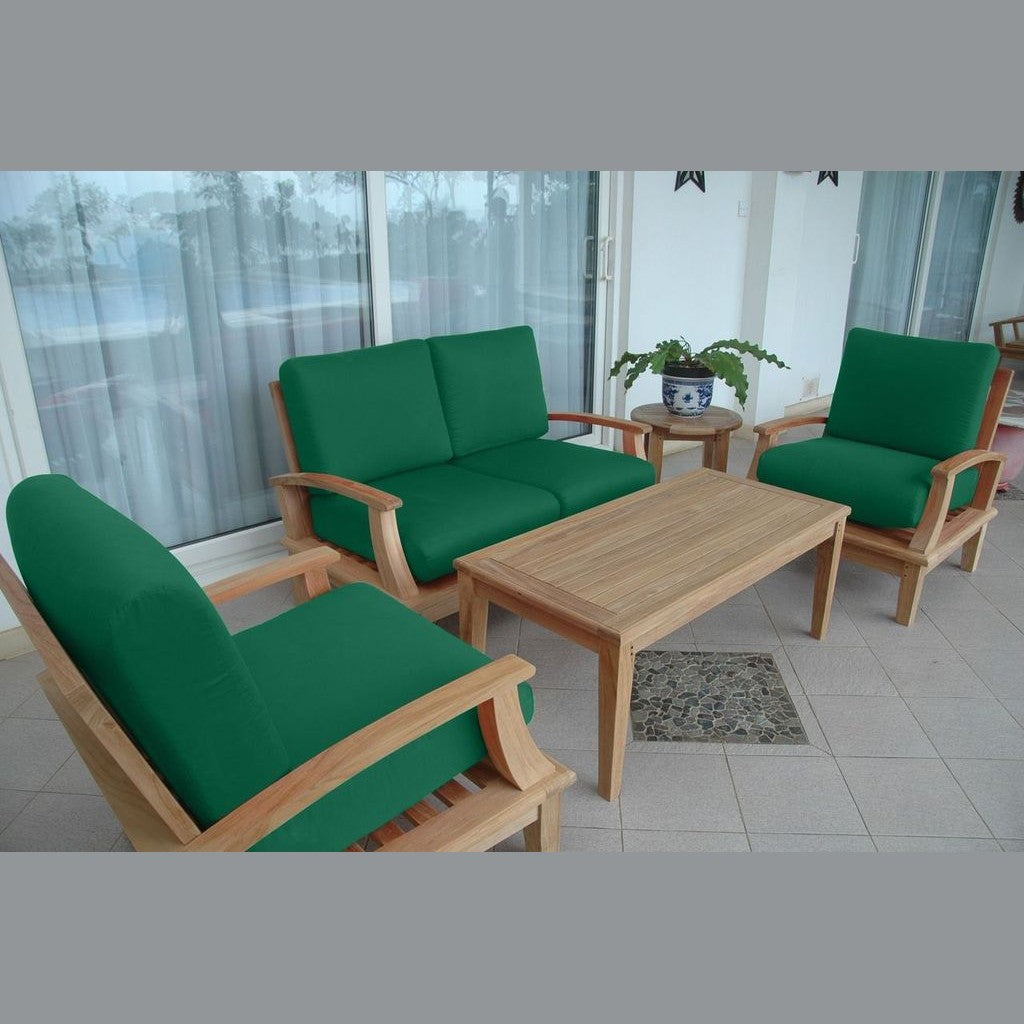 Green cushioned outdoor furniture set with a wooden table on a patio.