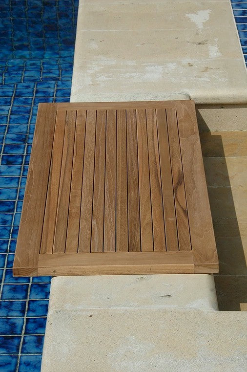 Wooden step on a pool deck with blue tiles