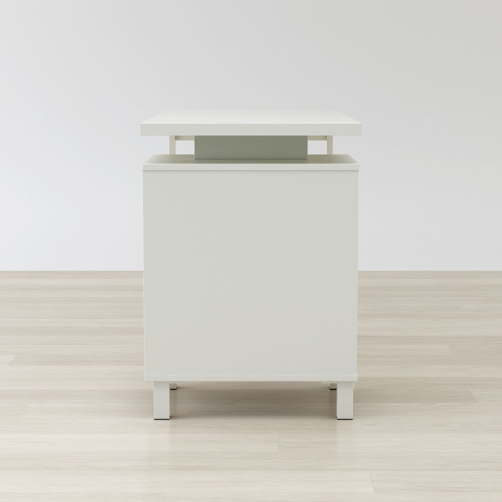 White nightstand with a green accent on a wooden floor and white wall background