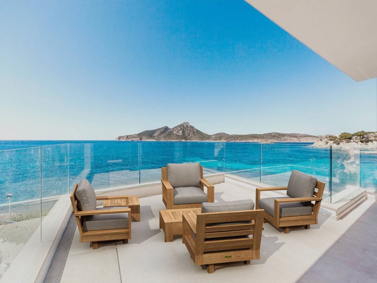 Outdoor furniture set on a balcony with a scenic view of the ocean and mountains.