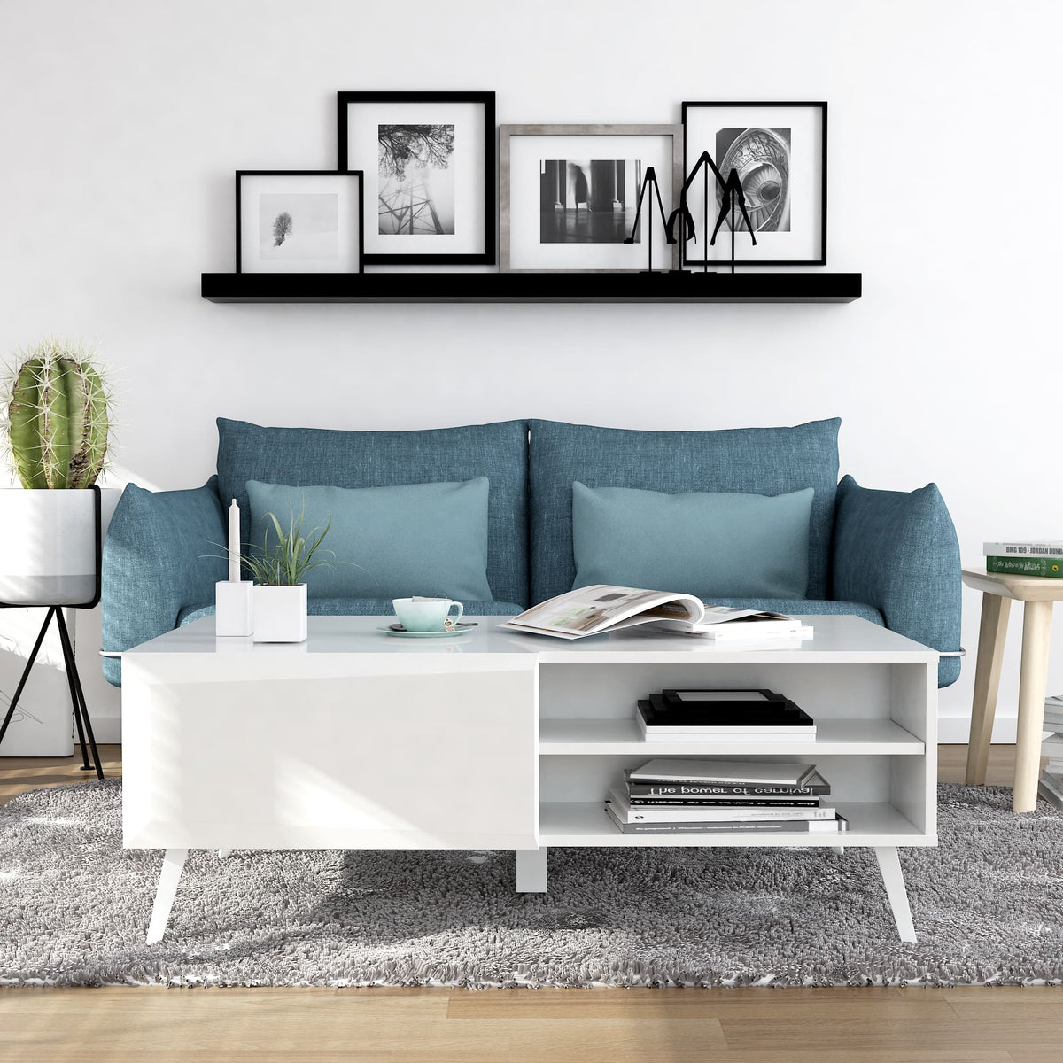 Modern living room with blue sofa, white coffee table, and decorative items.
