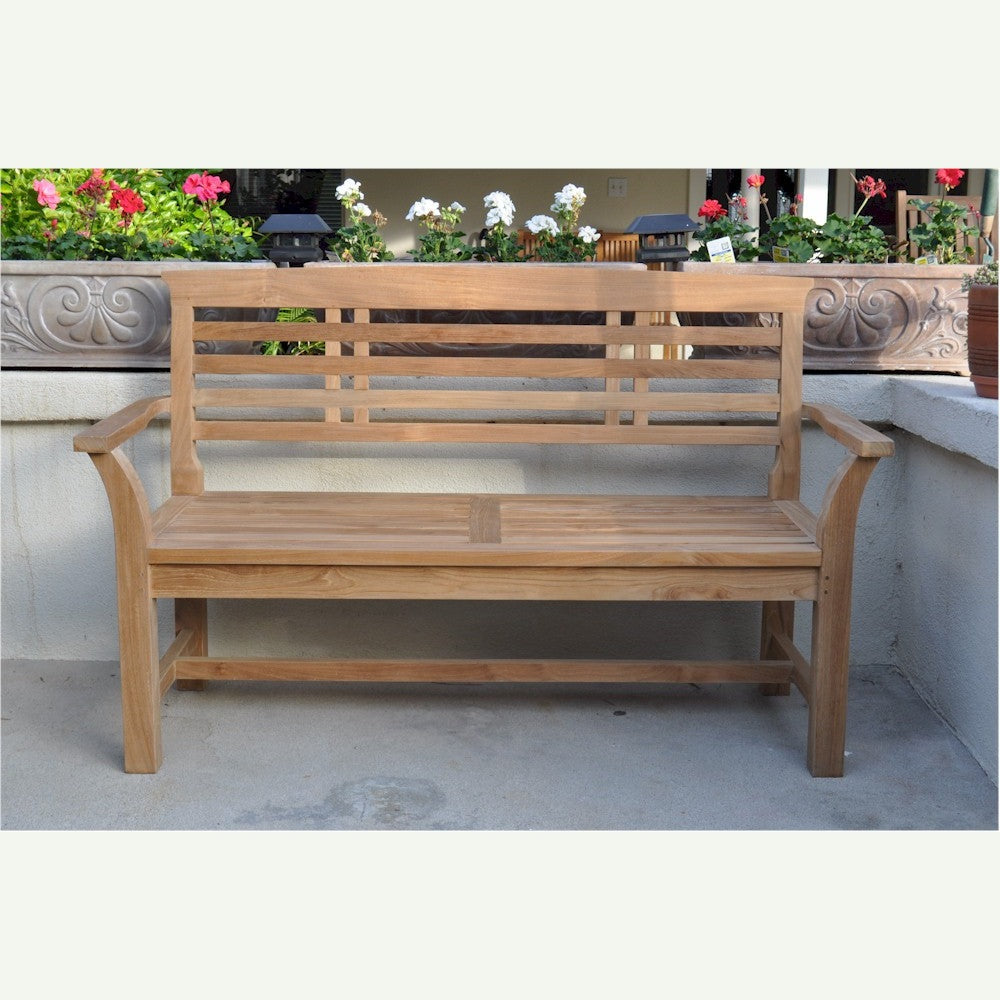 Wooden bench on a patio with flowers in the background