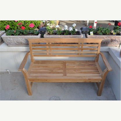 Wooden bench on a patio with potted plants in the background