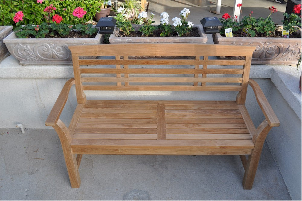 Wooden bench on a patio with potted plants in the background