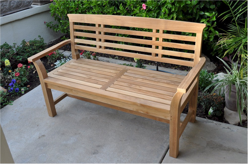 Wooden bench in a garden setting with flowers and plants around