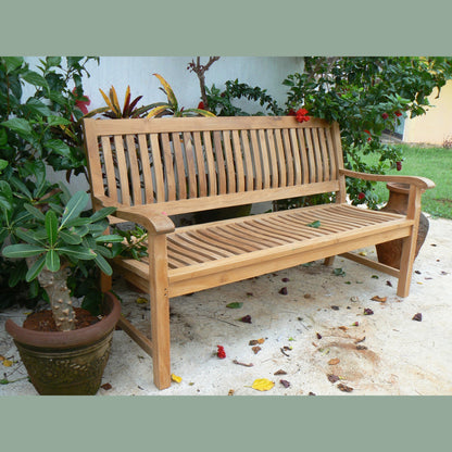 Wooden bench in a garden setting with plants and a light surface.