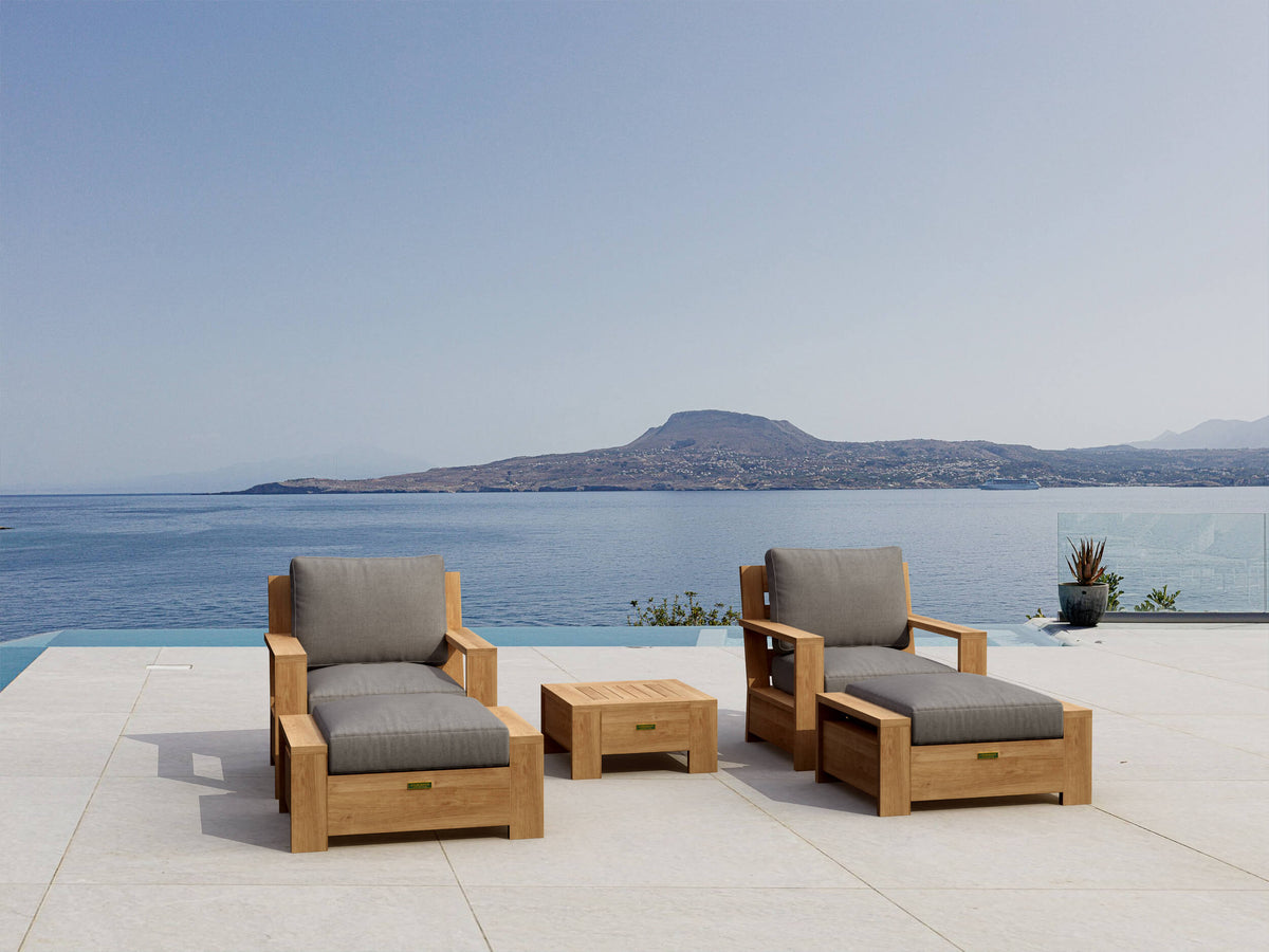 Outdoor furniture set with gray cushions by a pool with a mountain view.
