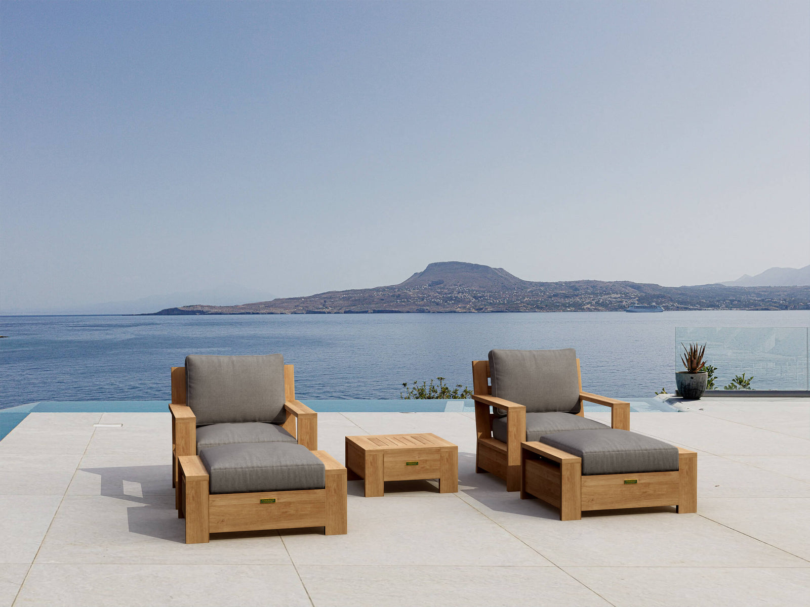 Outdoor furniture set with gray cushions by a pool with a mountain view.