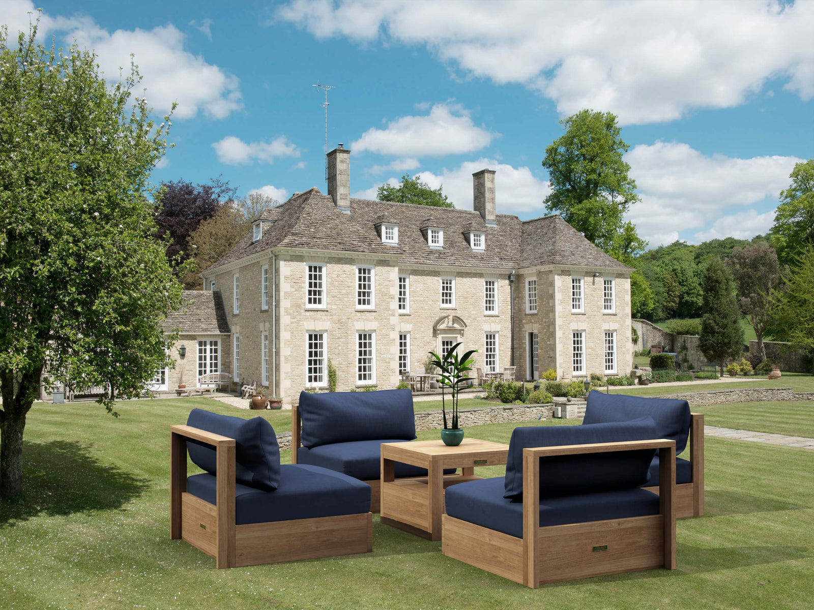 Outdoor furniture set with blue cushions in front of a large house.