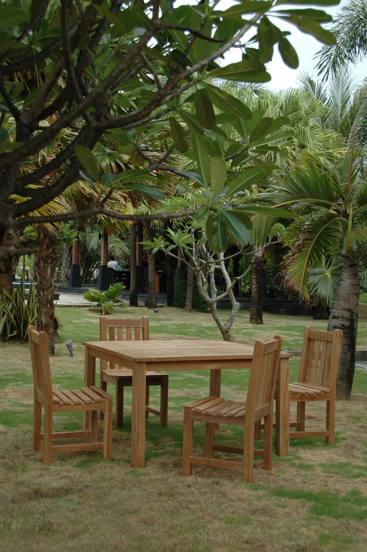 Wooden outdoor dining set with table and chairs in a garden setting