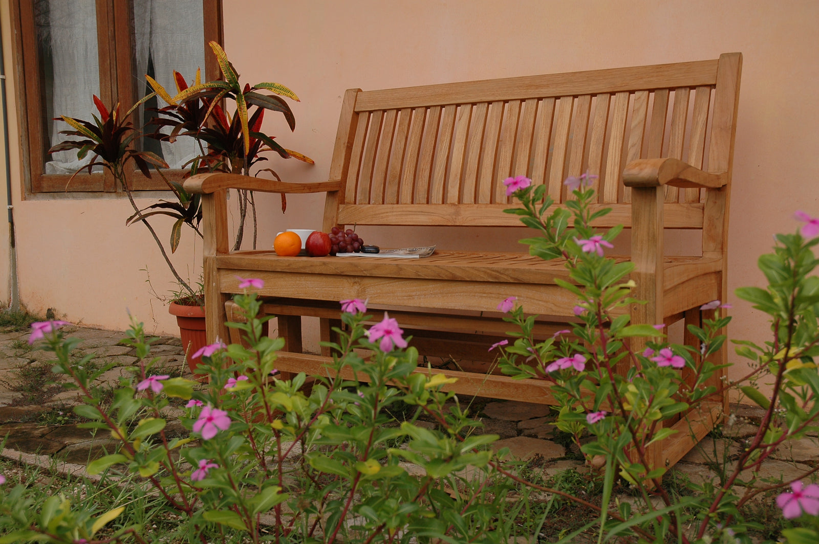 Wooden bench in a garden with flowers and fruits on it