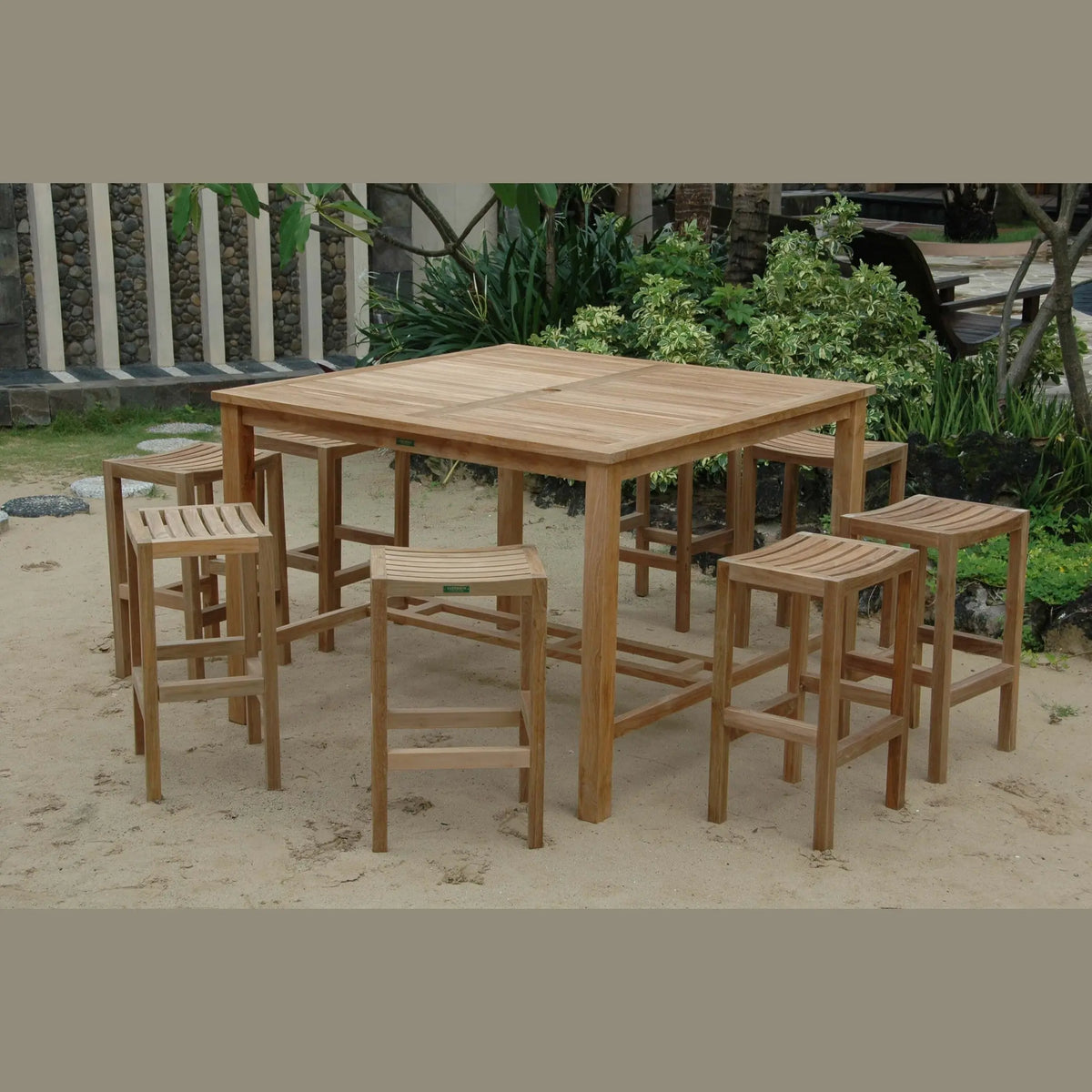 Wooden outdoor dining set with table and stools on sandy ground