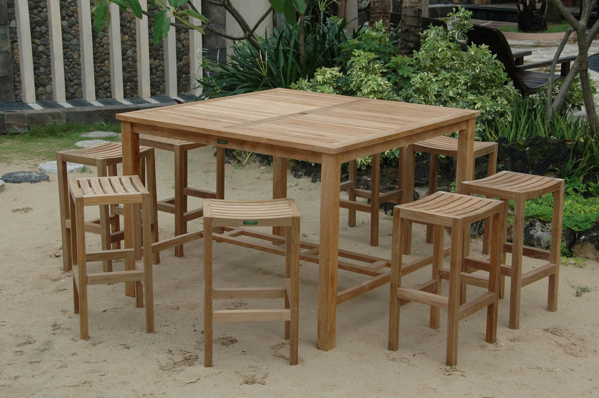 Wooden outdoor dining set with table and stools on sandy ground