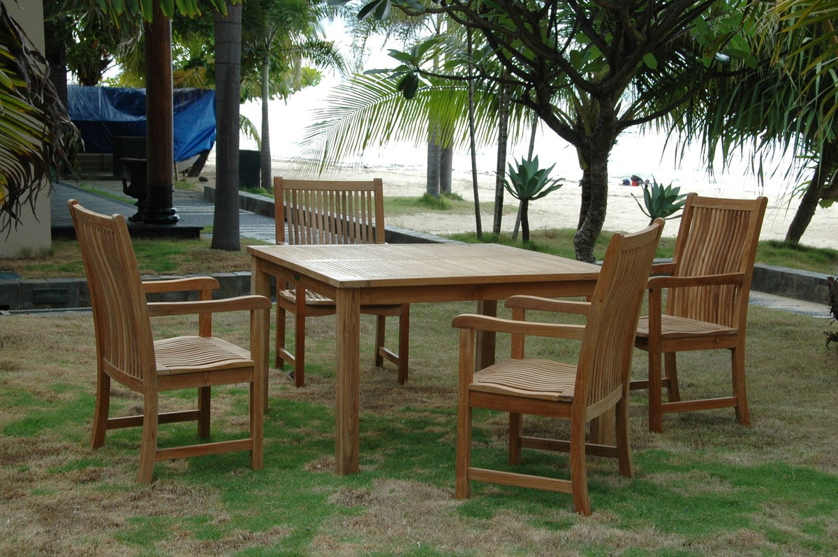 Wooden outdoor dining set with chairs on a grassy area near trees and a body of water.