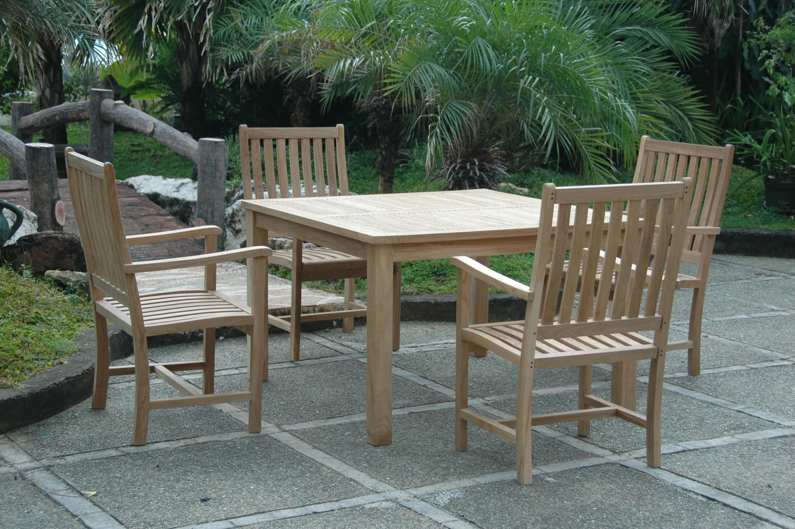 Wooden outdoor dining set with table and chairs on a stone patio