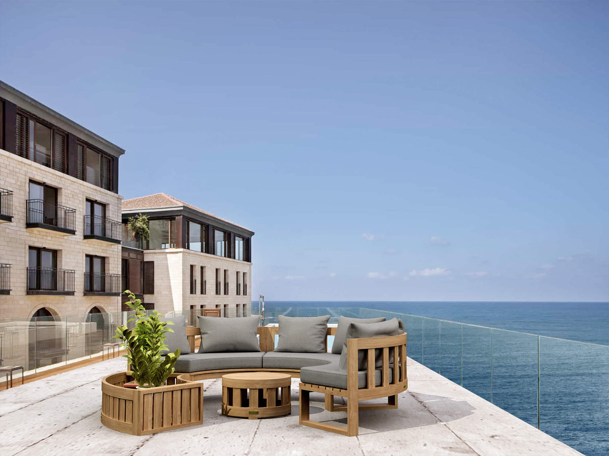 Outdoor furniture set on a balcony with ocean view and cityscape in the background