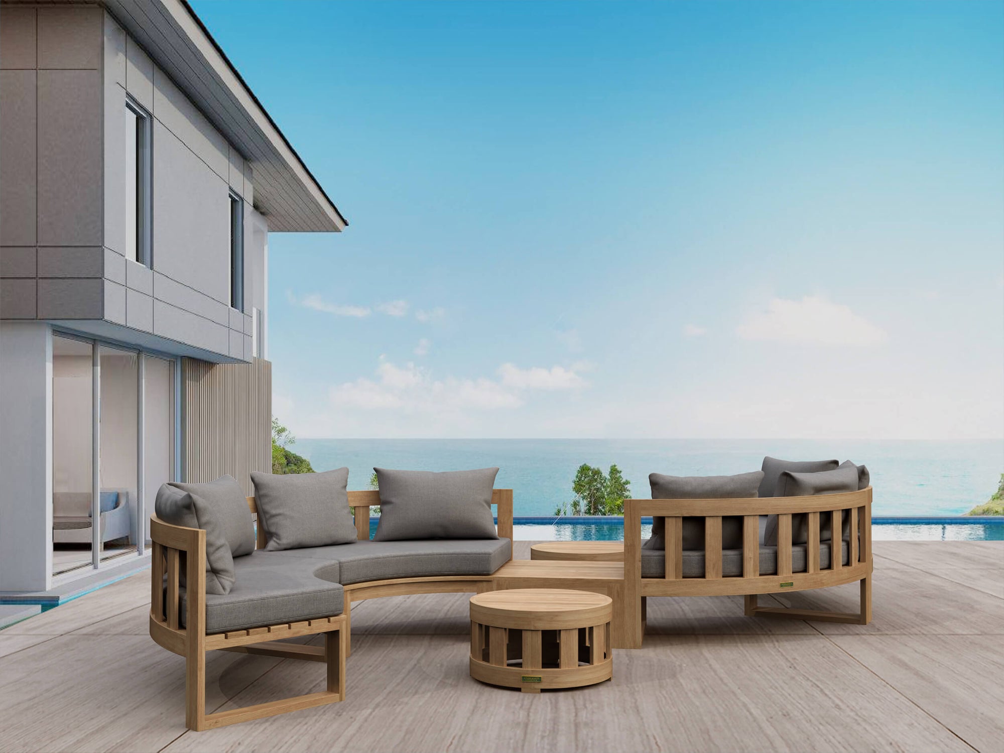 Outdoor wooden furniture set with gray cushions on a deck with a view of the ocean.