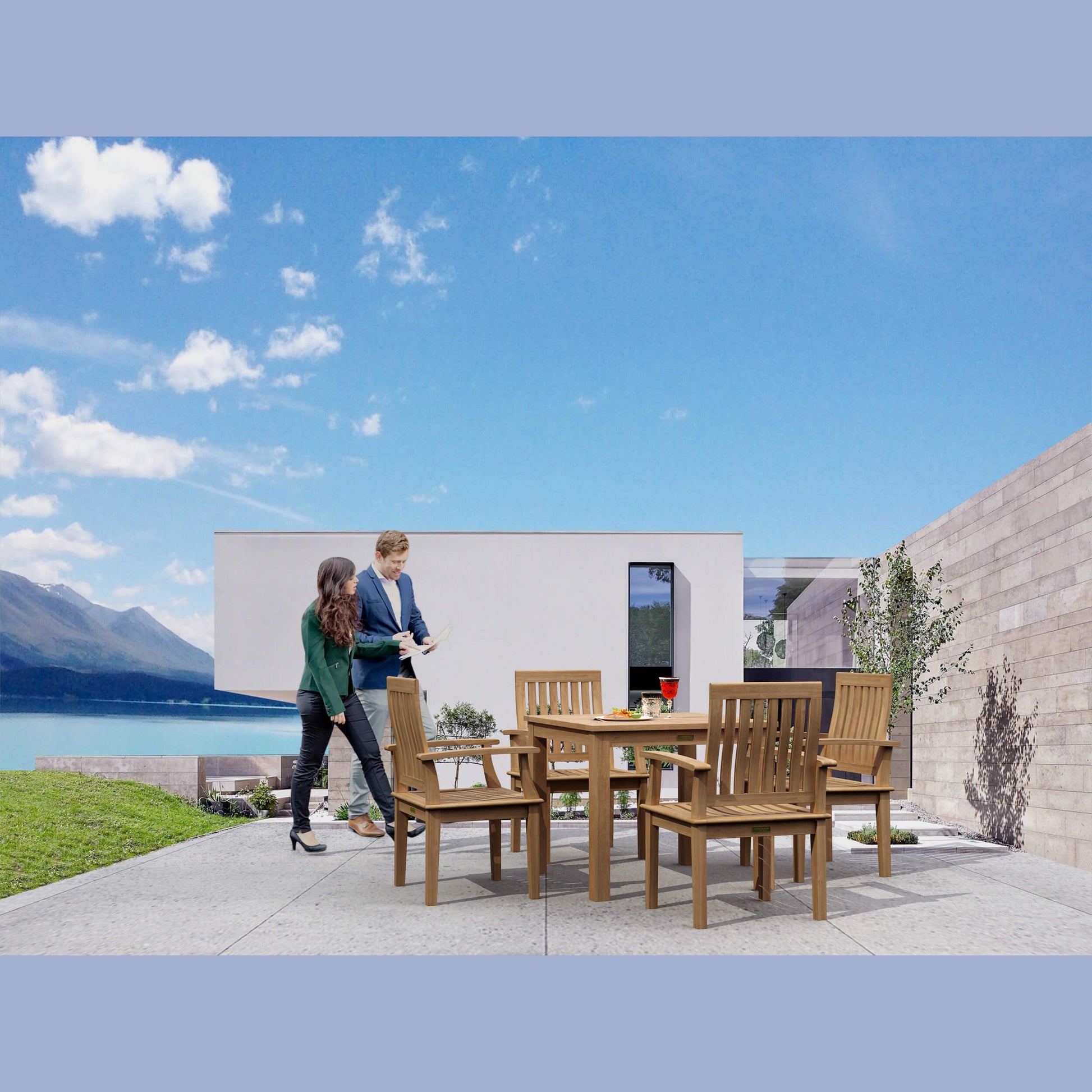 Two people standing near a wooden outdoor dining set with a scenic background.