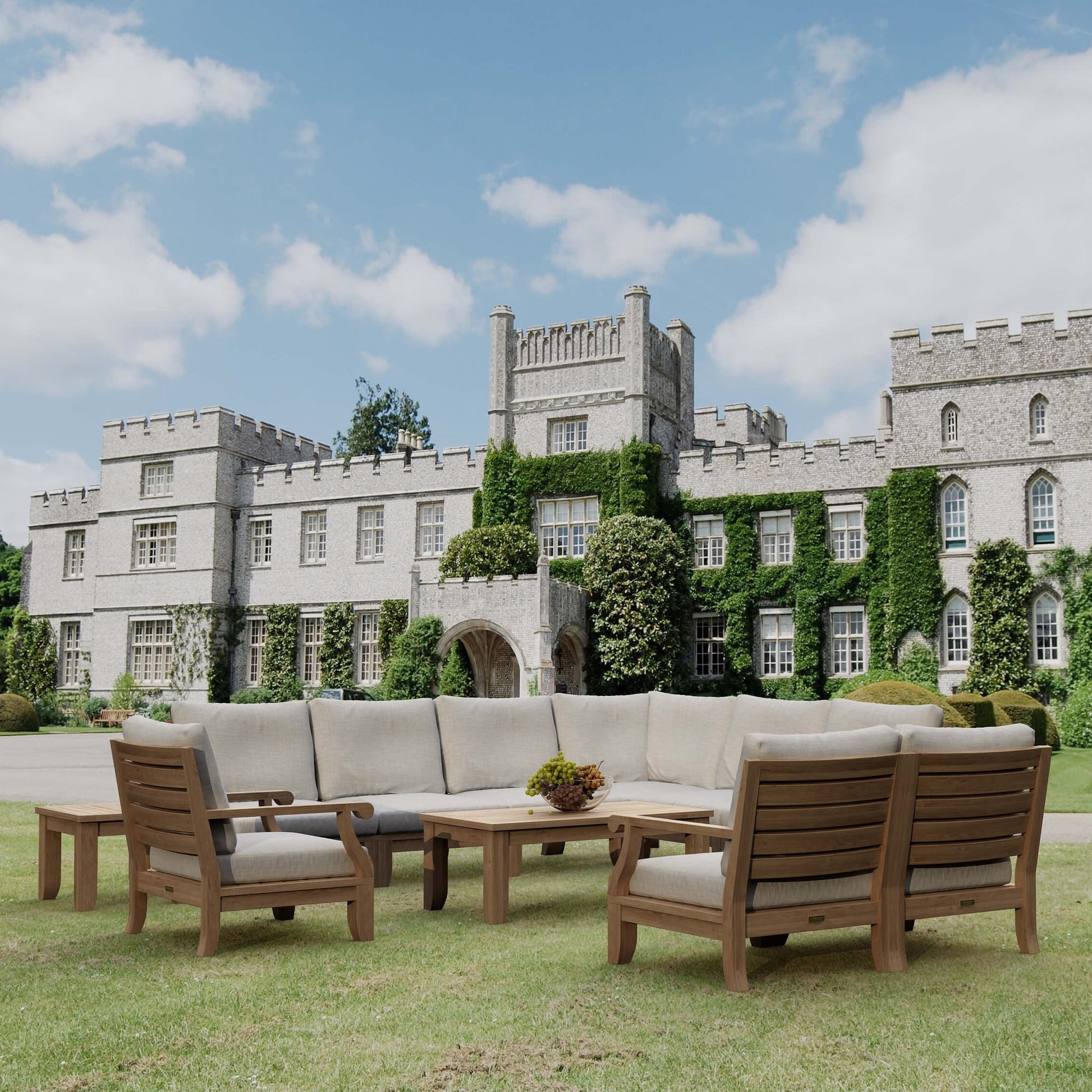 Outdoor furniture set on a grassy lawn with a castle in the background