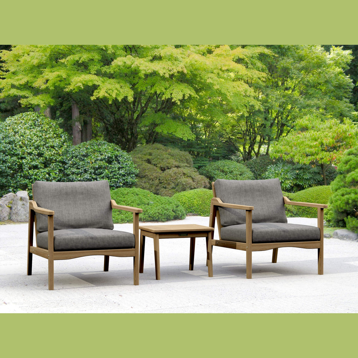 Two gray cushioned chairs with wooden frames and a matching table in a garden setting.