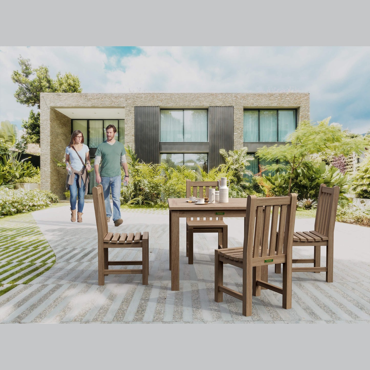 Wooden outdoor dining set with people walking towards a modern house.