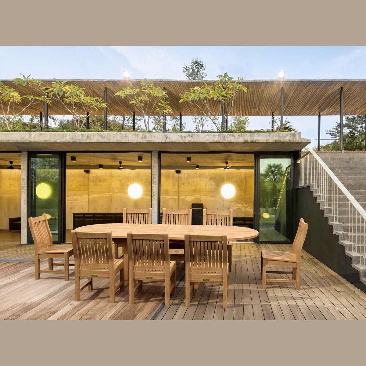 Wooden outdoor dining set on a deck with modern building in the background