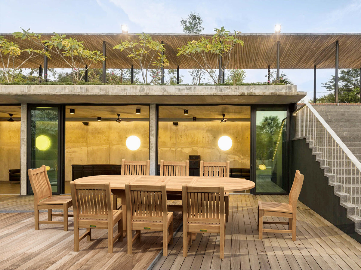 Wooden outdoor dining set on a deck with modern building in the background