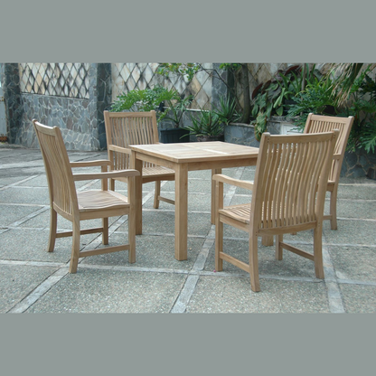 Outdoor teak furniture set with a table and four chairs on a stone patio.