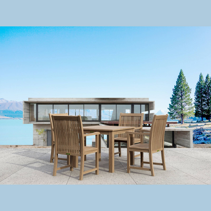 Outdoor dining set with table and chairs by a waterfront building.