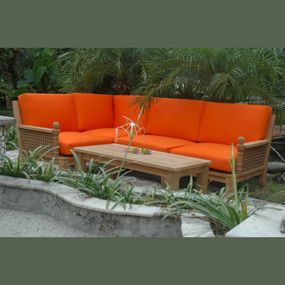 Orange outdoor sofa set with wooden coffee table in a garden setting