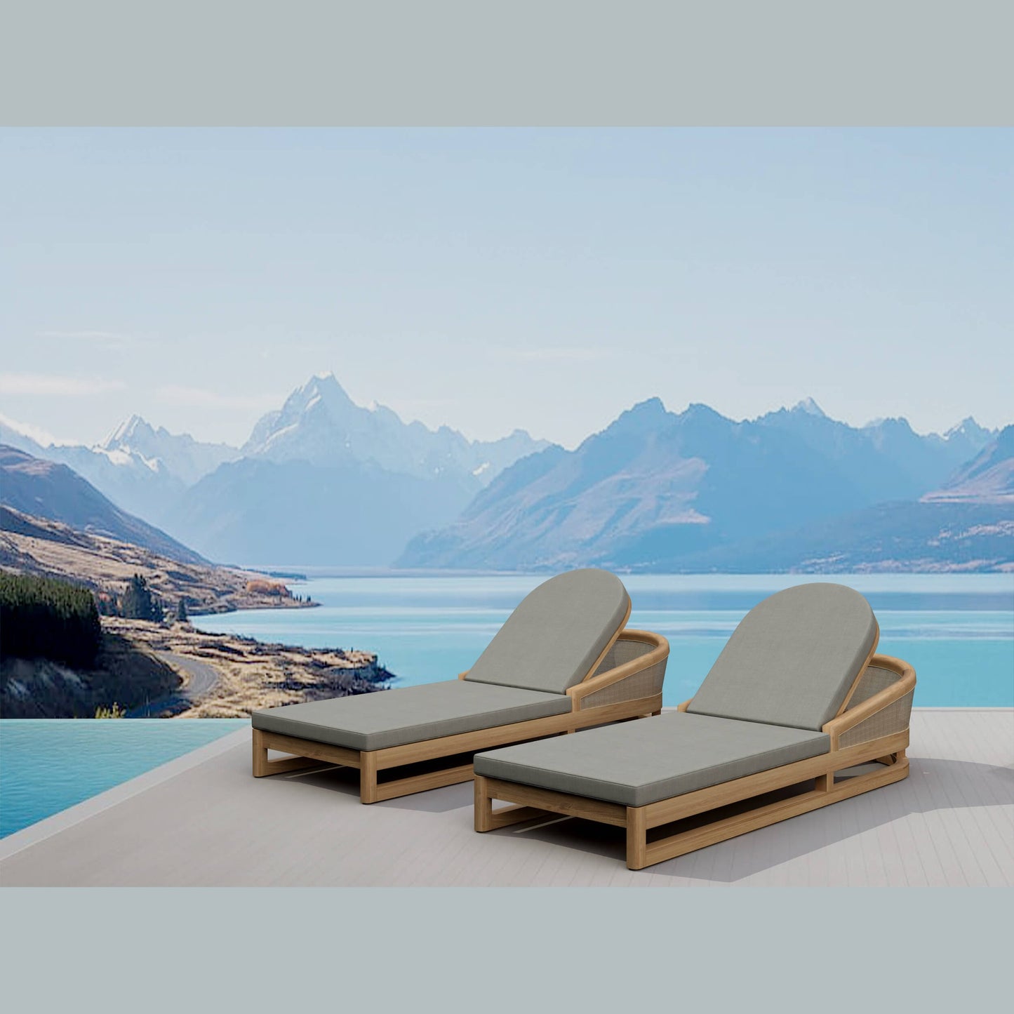 Two lounge chairs with gray cushions on a deck overlooking a lake and mountains.