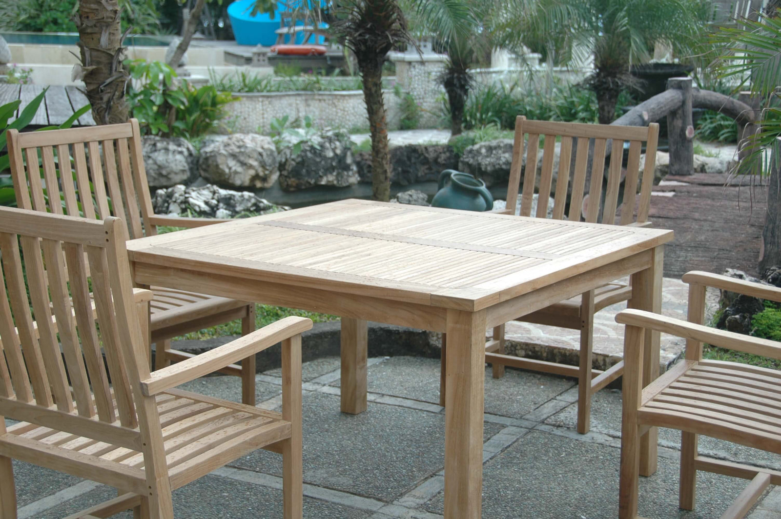 Wooden outdoor table and chairs set with a garden background