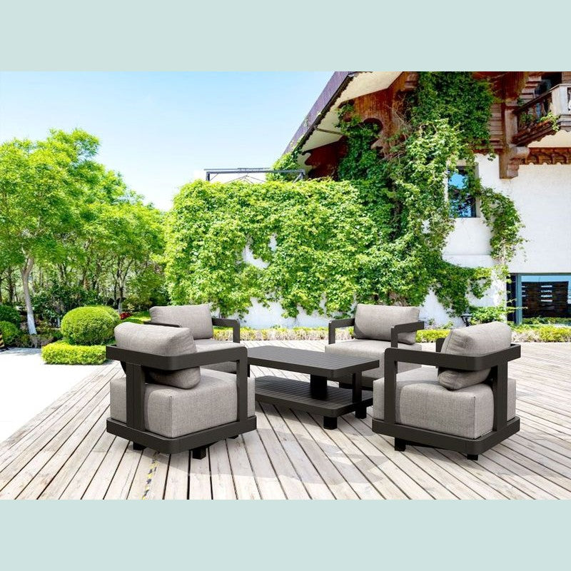 Outdoor patio furniture set on a wooden deck with greenery and a building in the background