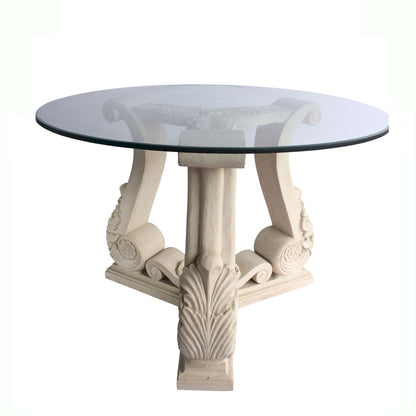Round glass-top table with decorative white legs on a white background