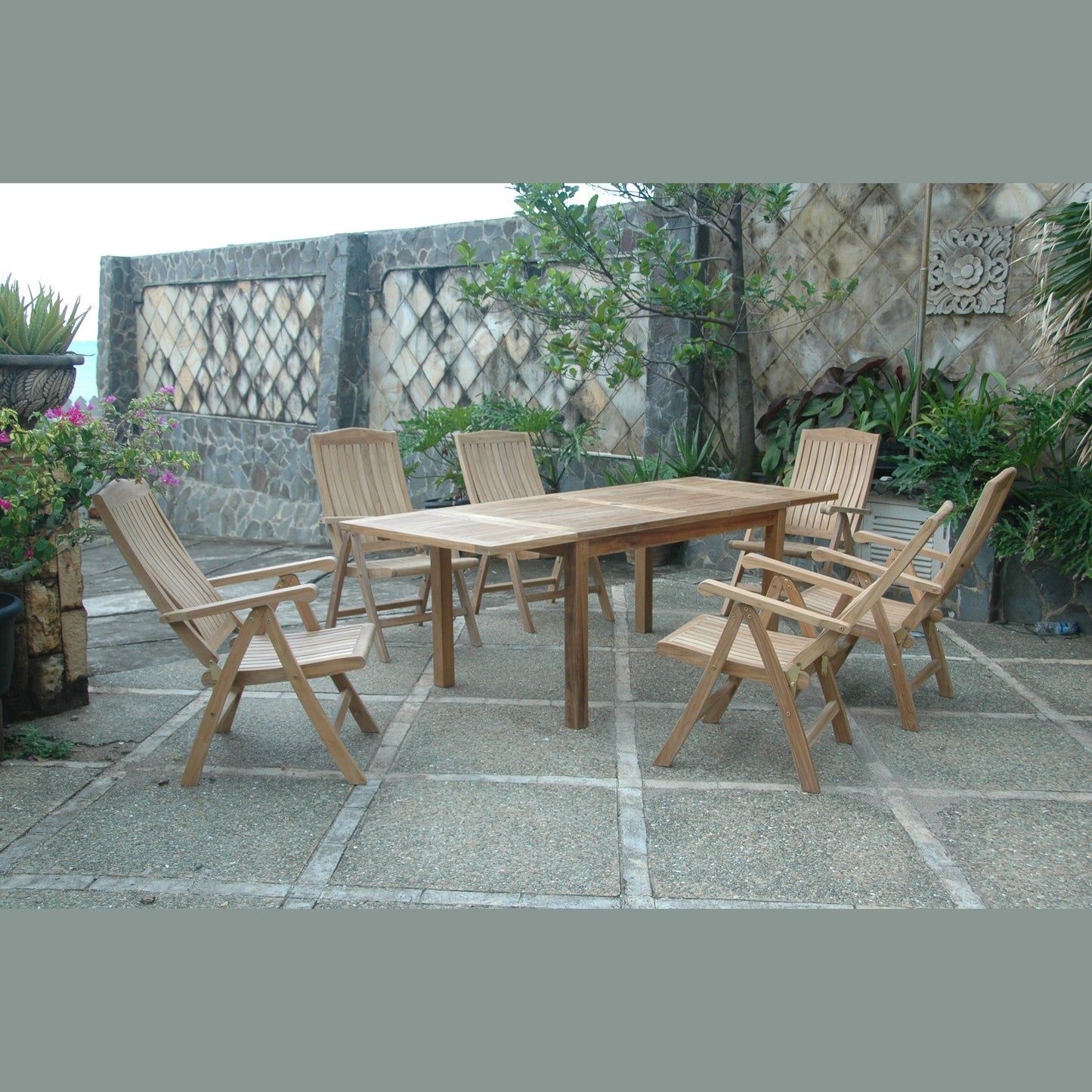 Wooden outdoor dining set with chairs on a stone patio