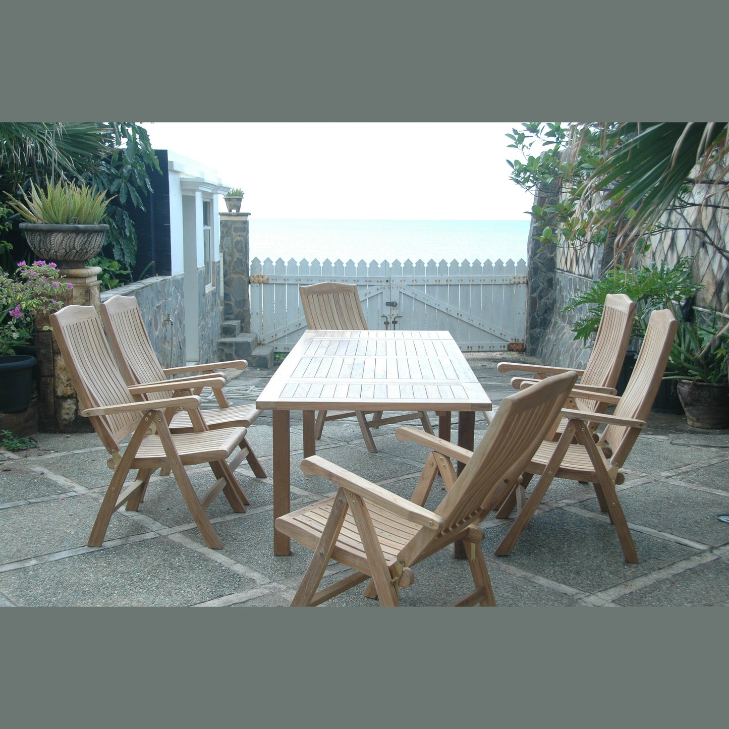 Wooden outdoor dining set with chairs on a stone patio