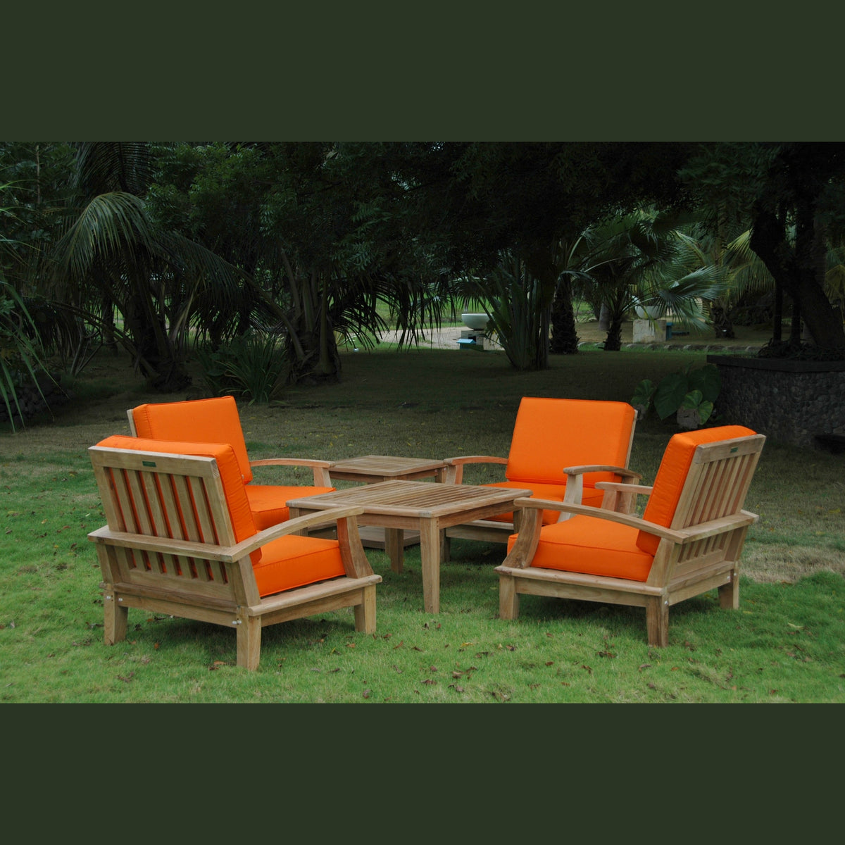 Outdoor furniture set with orange cushions and wooden frames on a grassy area.