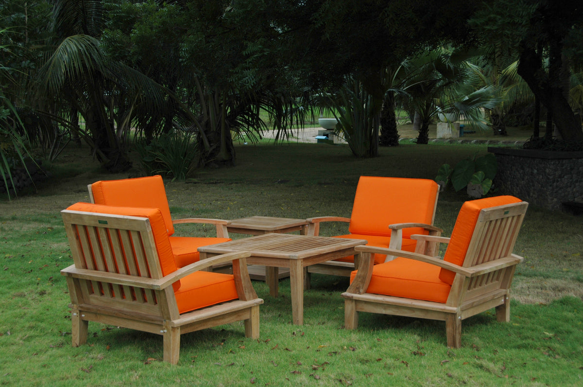 Outdoor furniture set with orange cushions and wooden frames on a grassy area.