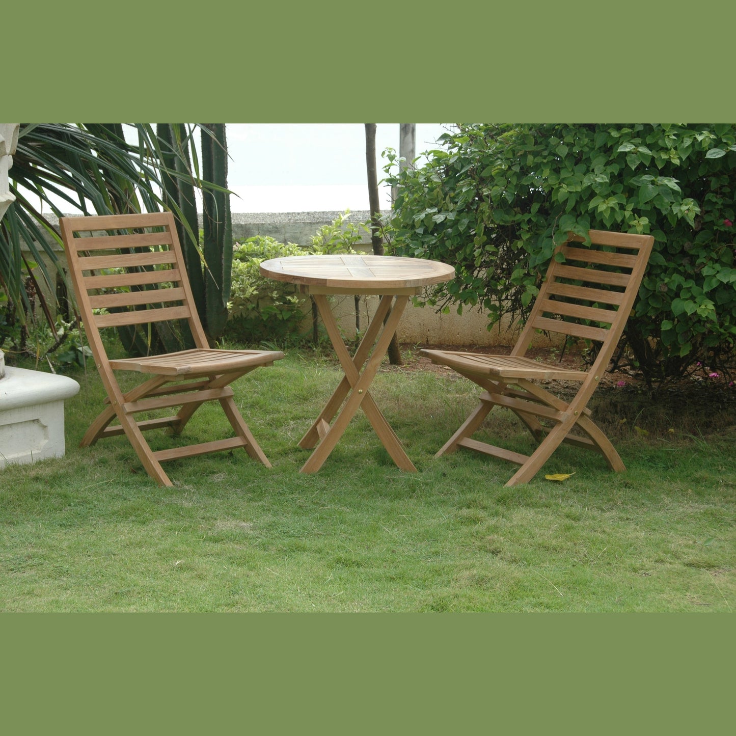 Wooden outdoor table and chairs on a grassy area with greenery in the background