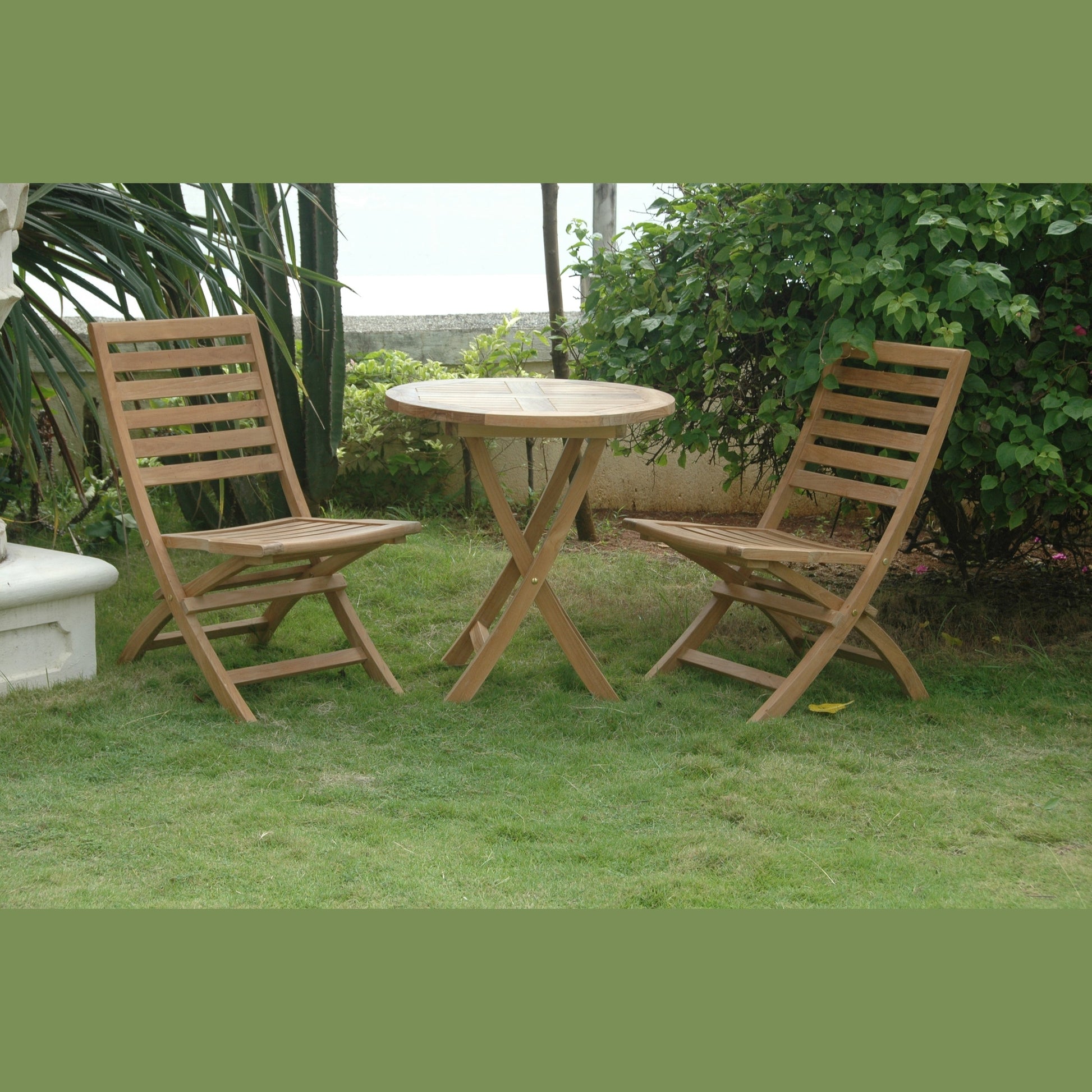 Wooden outdoor table and chairs on a grassy area with greenery in the background