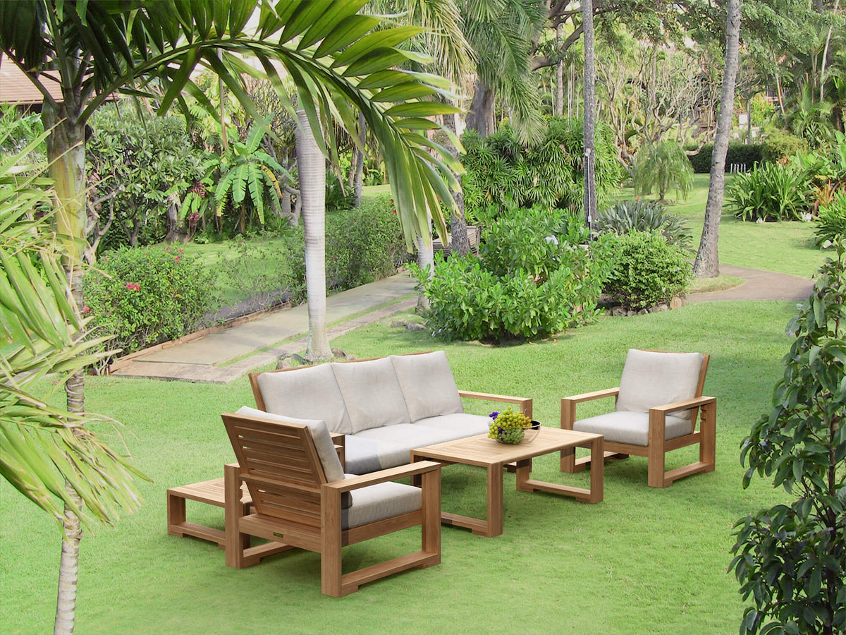 Outdoor furniture set on a grassy area with palm trees and greenery